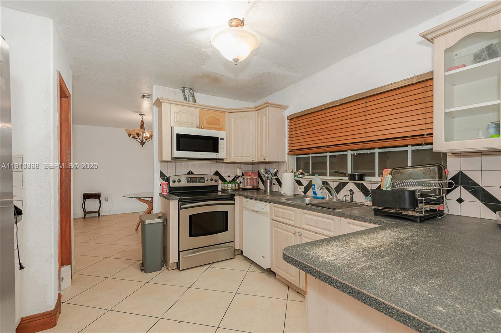 18890 Southwest 184th Street Miami, FL 33187 - Photo 4 of 37 a kitchen with a stove a sink and a microwave