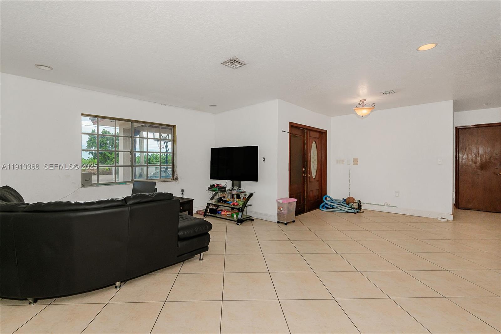 18890 Southwest 184th Street Miami, FL 33187 - Photo 8 of 37 a living room with furniture and a flat screen tv