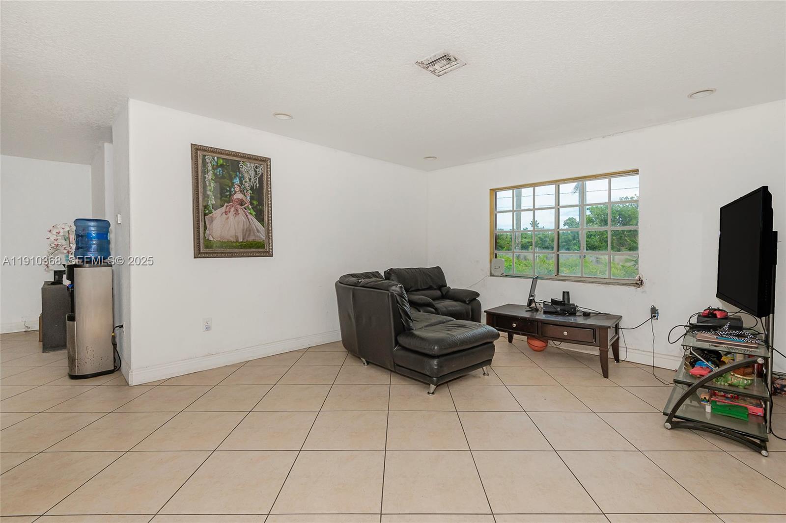18890 Southwest 184th Street Miami, FL 33187 - Photo 9 of 37 a living room with furniture and a flat screen tv