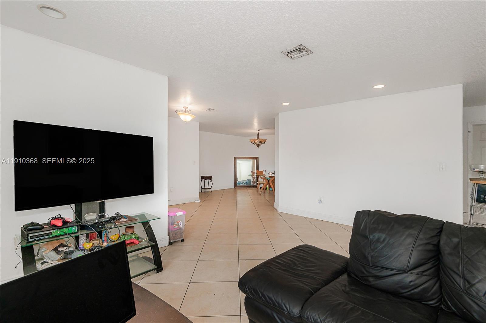18890 Southwest 184th Street Miami, FL 33187 - Photo 10 of 37 a living room with furniture and a flat screen tv