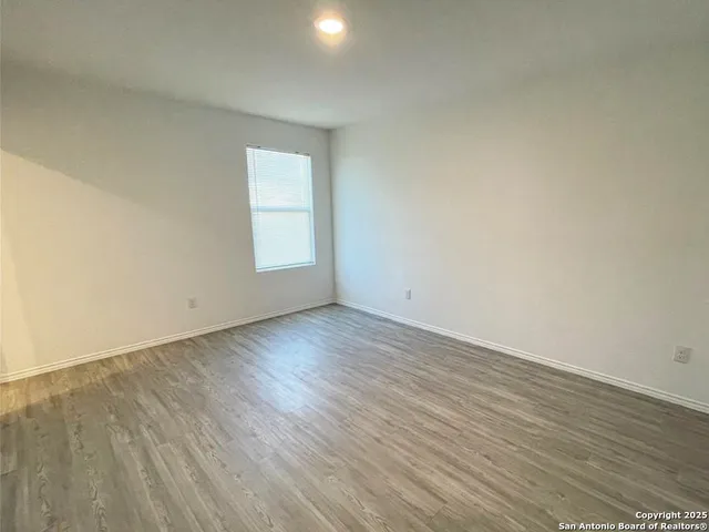 an empty room with wooden floor and window