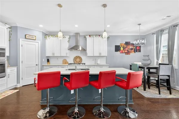 a kitchen with granite countertop a dining table chairs sink and white appliances
