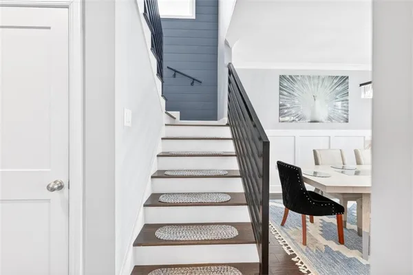 a living room with a bed furniture flat screen tv and a ceiling fan
