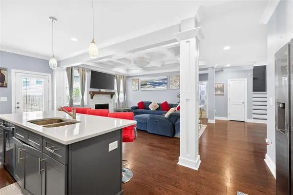 a view of kitchen with stainless steel appliances granite countertop a stove a sink a dining table and chairs with wooden floor