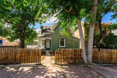 a front view of a house with a tree