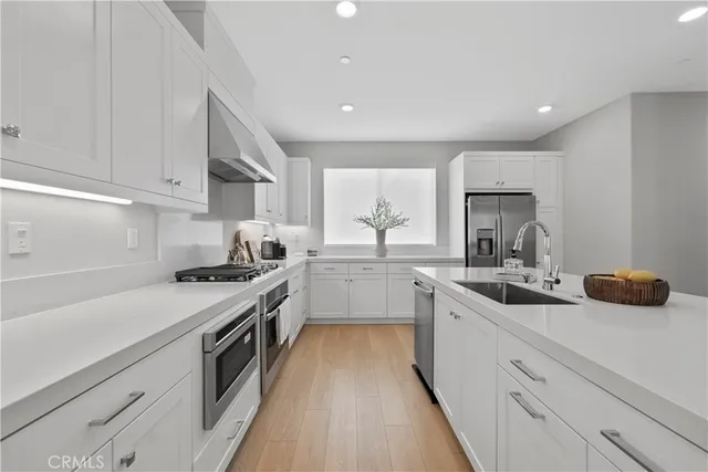 a kitchen with granite countertop a sink and white cabinets