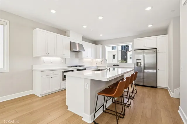 a kitchen with white cabinets and stainless steel appliances