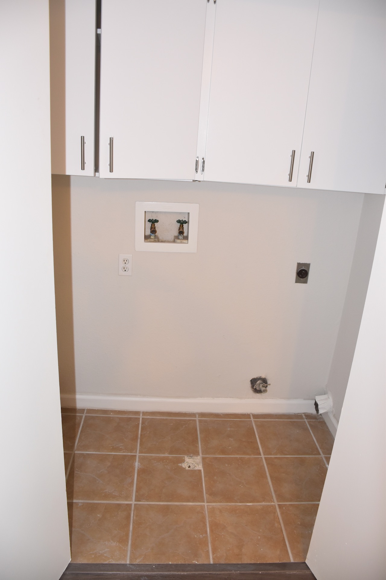 1810 Rawhide Loop Round Rock, TX 78681 - Photo 12 of 29 Dedicated laundry area featuring ceramic tile flooring, white shaker-style cabinetry with brushed nickel hardware, and utility hookups