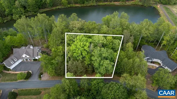 an aerial view of residential houses with outdoor space and lake view