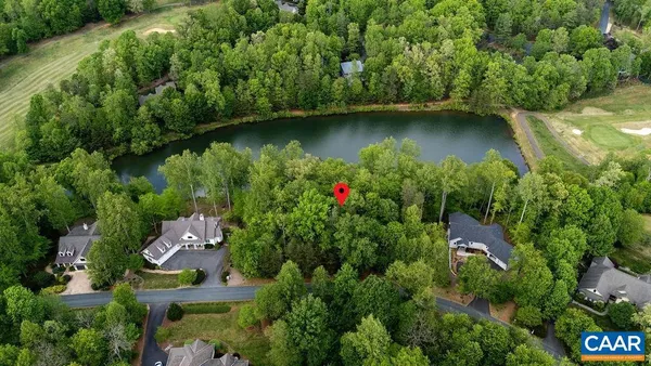 an aerial view of residential house with outdoor space and trees all around