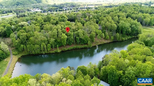 an aerial view of residential houses with outdoor space and lake view