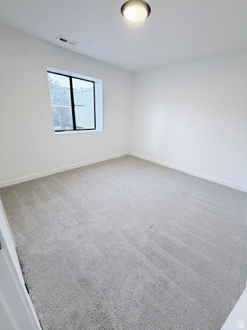 227 South West Lane Provo, UT 84601 - Photo 20 of 25 Room featuring light grey carpeting, white painted walls, a flush-mount ceiling light, and a large window with black trim
