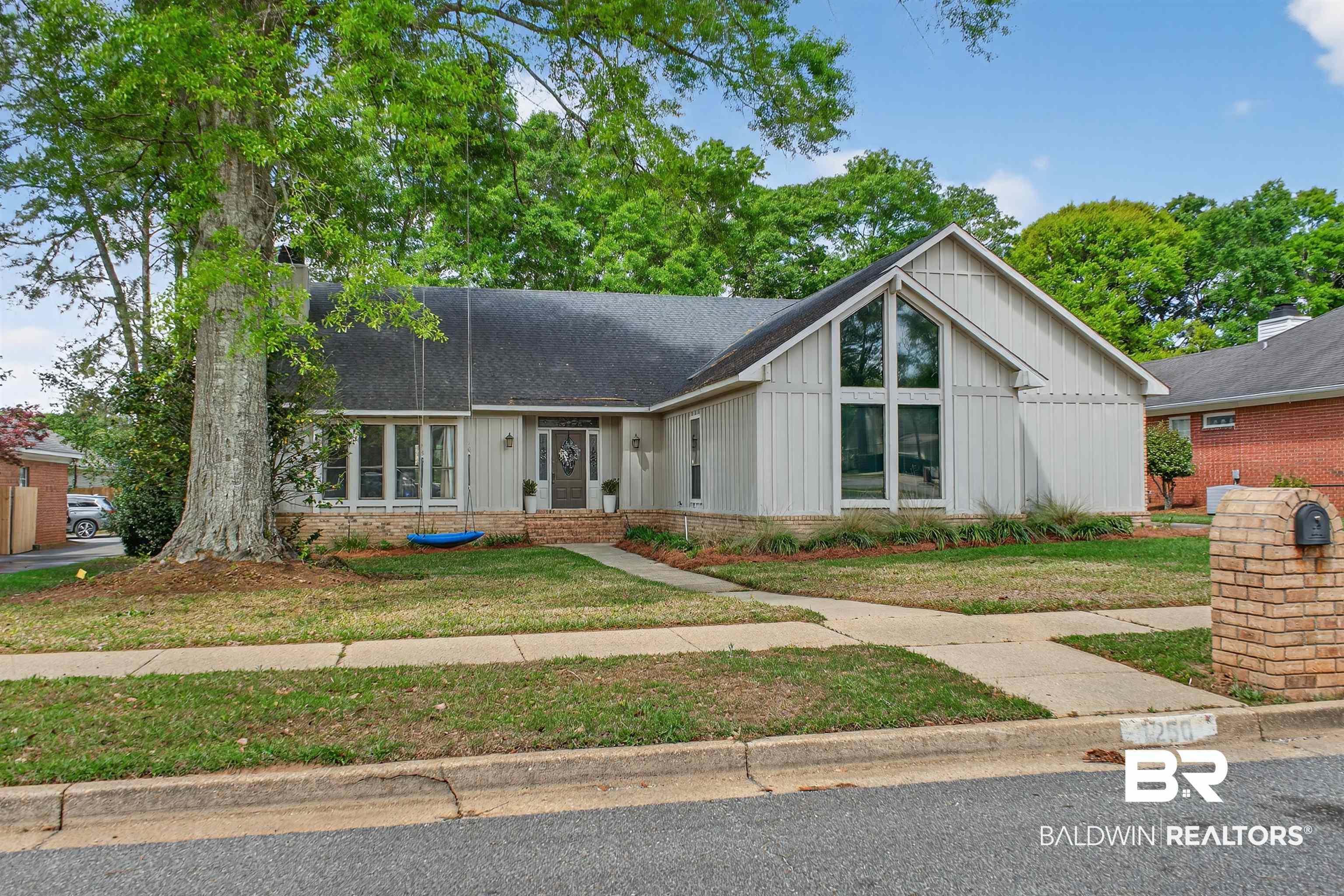 1250 Savannah Drive Mobile, AL 36609 - Photo 2 of 35 View of front facade featuring brick siding, board and batten siding, a shingled roof, and a front lawn