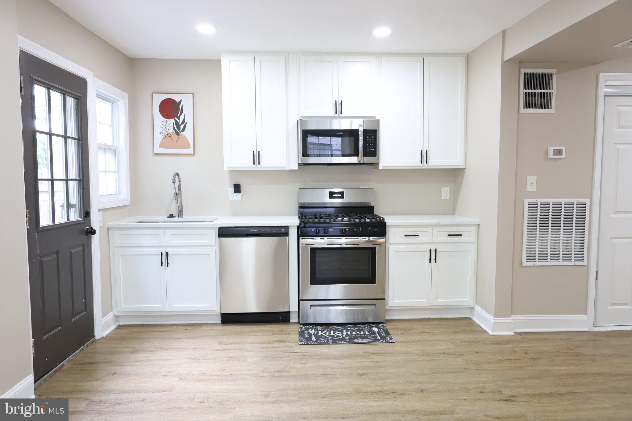 1316 Eastern Avenue Northeast Washington, DC 20019 - Photo 12 of 31 a kitchen with stainless steel appliances a stove a microwave and white cabinets