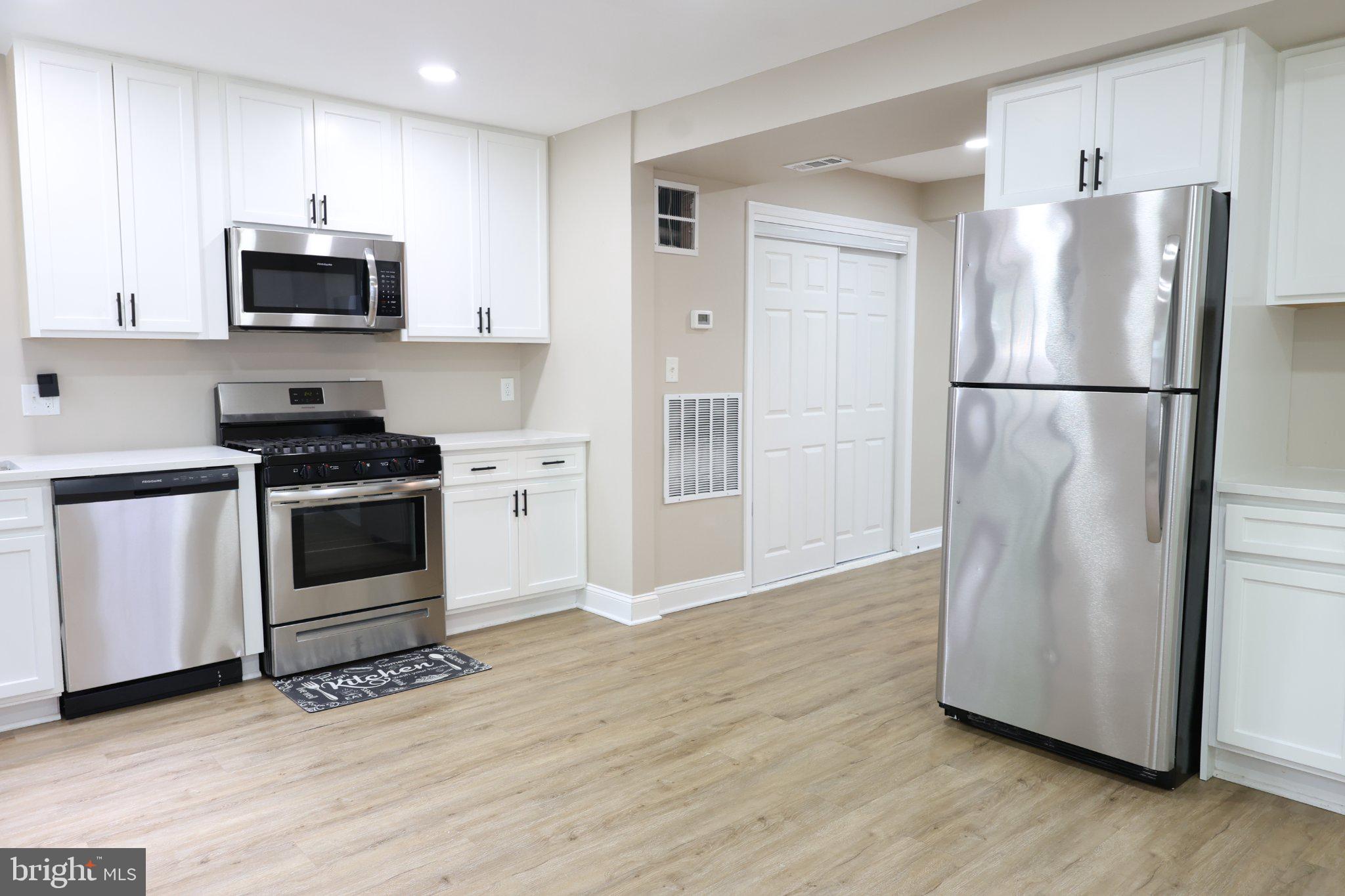 1316 Eastern Avenue Northeast Washington, DC 20019 - Photo 13 of 31 a kitchen with a refrigerator stove and wooden cabinets