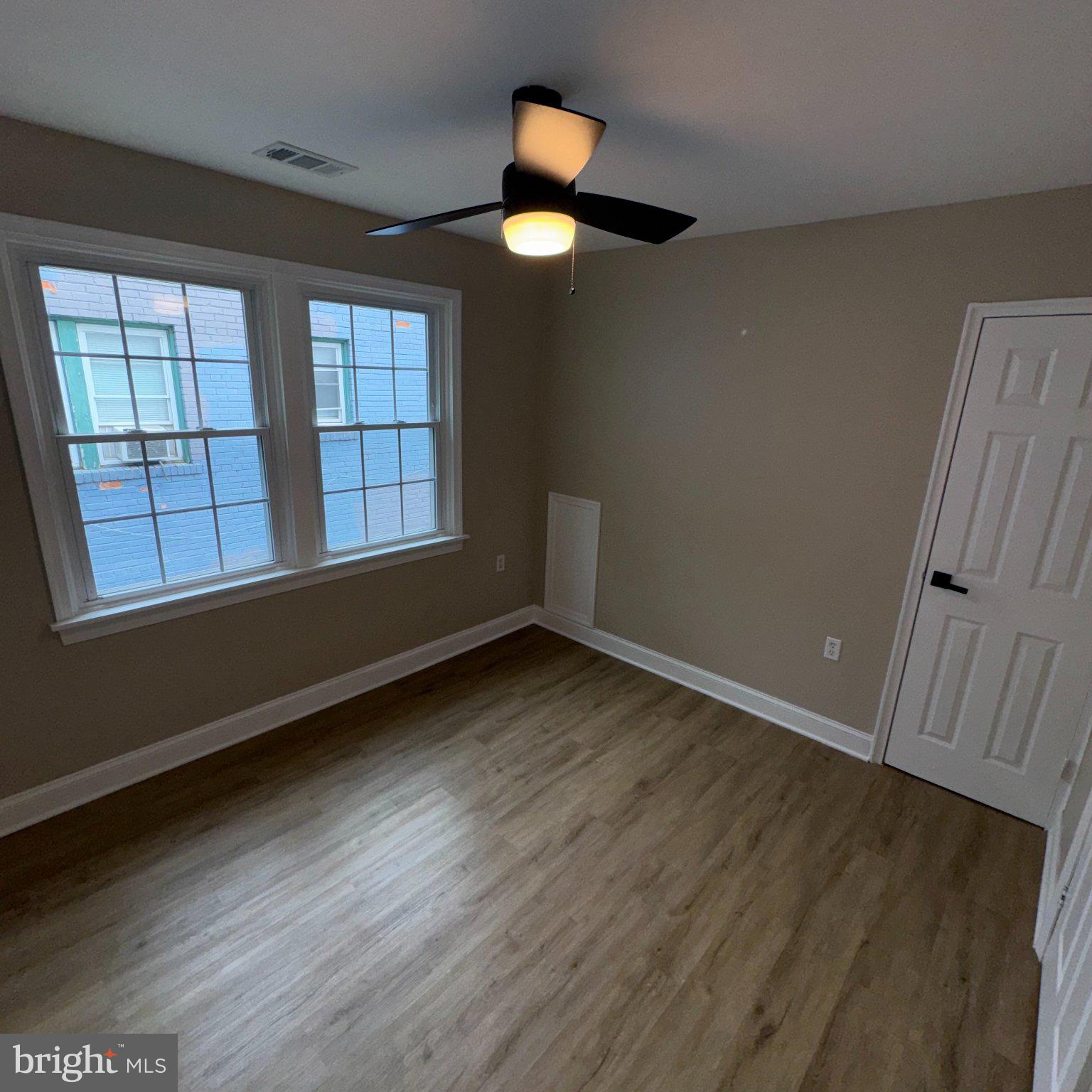 1316 Eastern Avenue Northeast Washington, DC 20019 - Photo 18 of 31 an empty room with wooden floor and windows