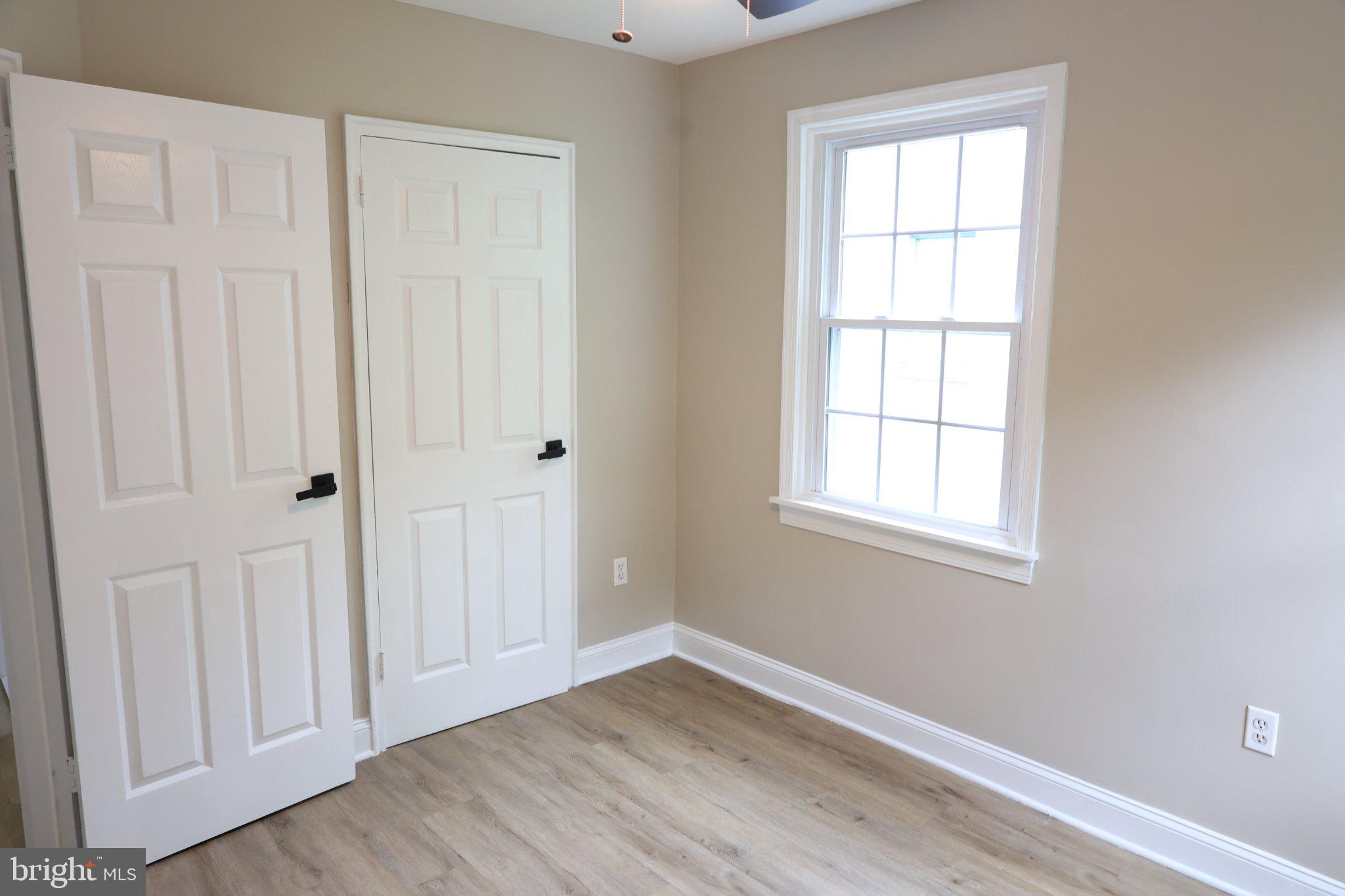 1316 Eastern Avenue Northeast Washington, DC 20019 - Photo 21 of 31 an empty room with wooden floor and windows