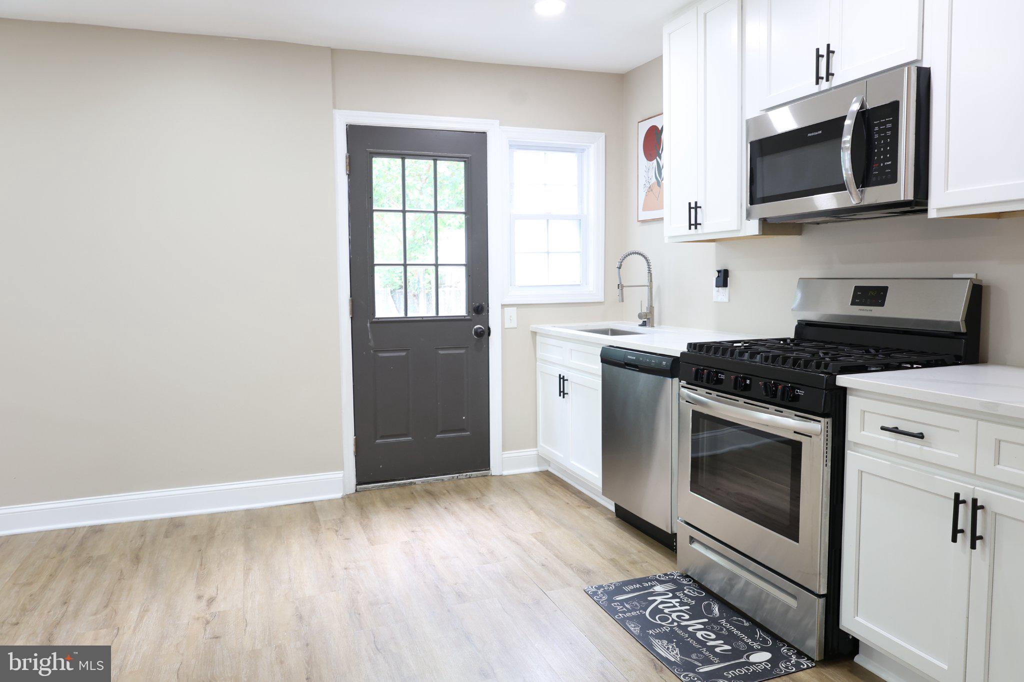 1316 Eastern Avenue Northeast Washington, DC 20019 - Photo 29 of 31 a kitchen with stainless steel appliances granite countertop a stove a sink and a microwave