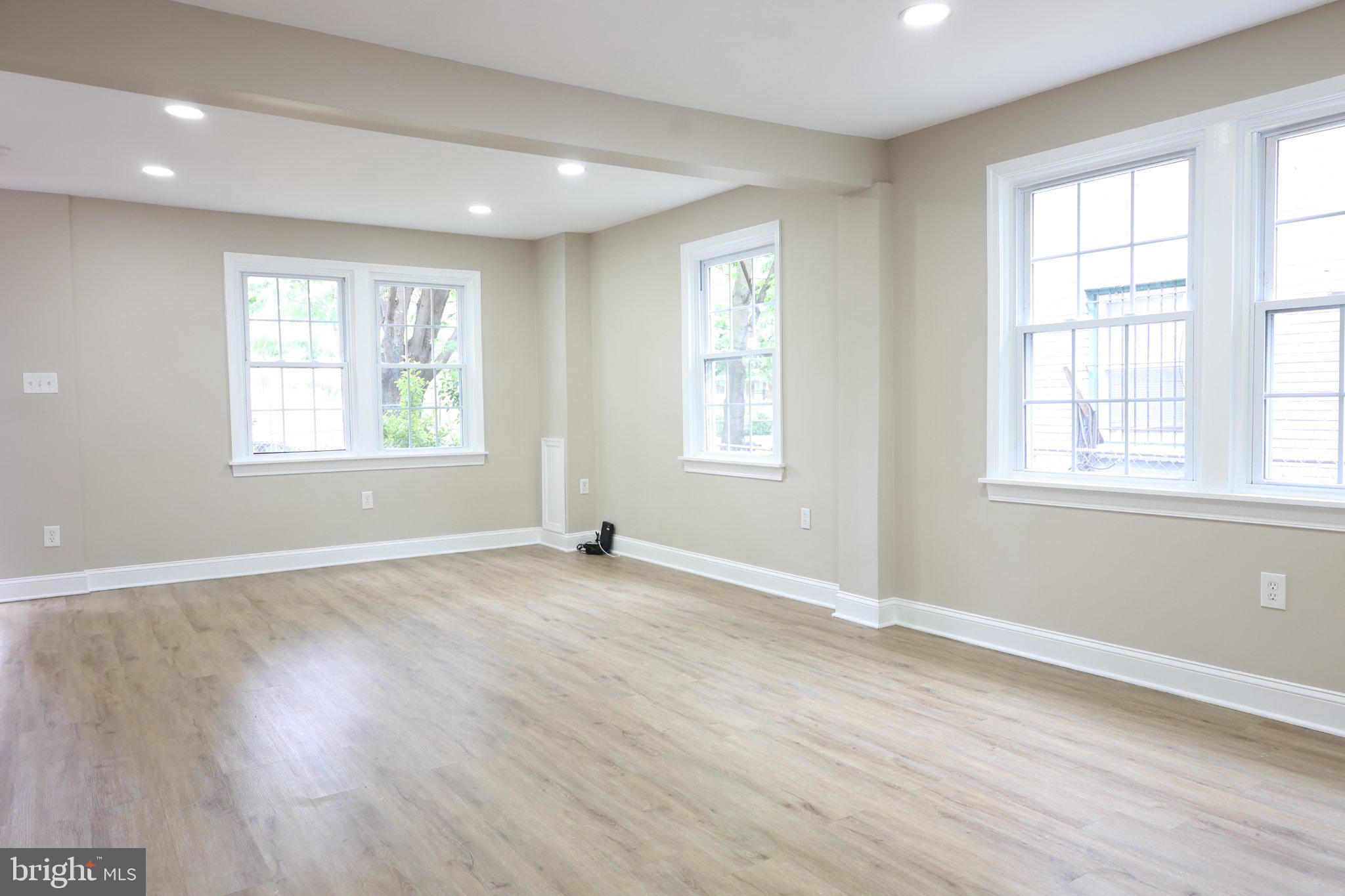 1316 Eastern Avenue Northeast Washington, DC 20019 - Photo 5 of 31 an empty room with wooden floor and windows