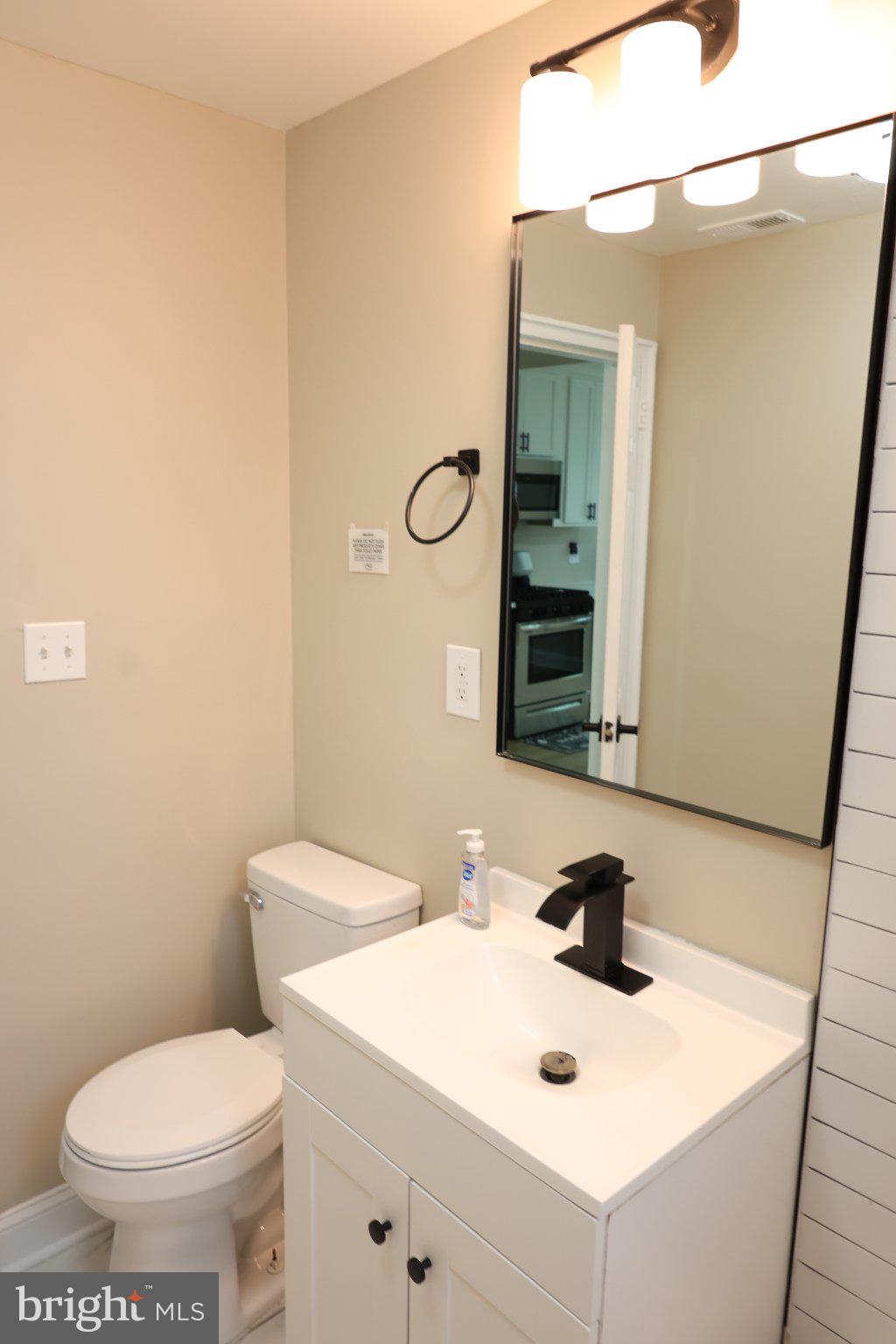 1316 Eastern Avenue Northeast Washington, DC 20019 - Photo 6 of 31 a bathroom with a toilet sink and mirror
