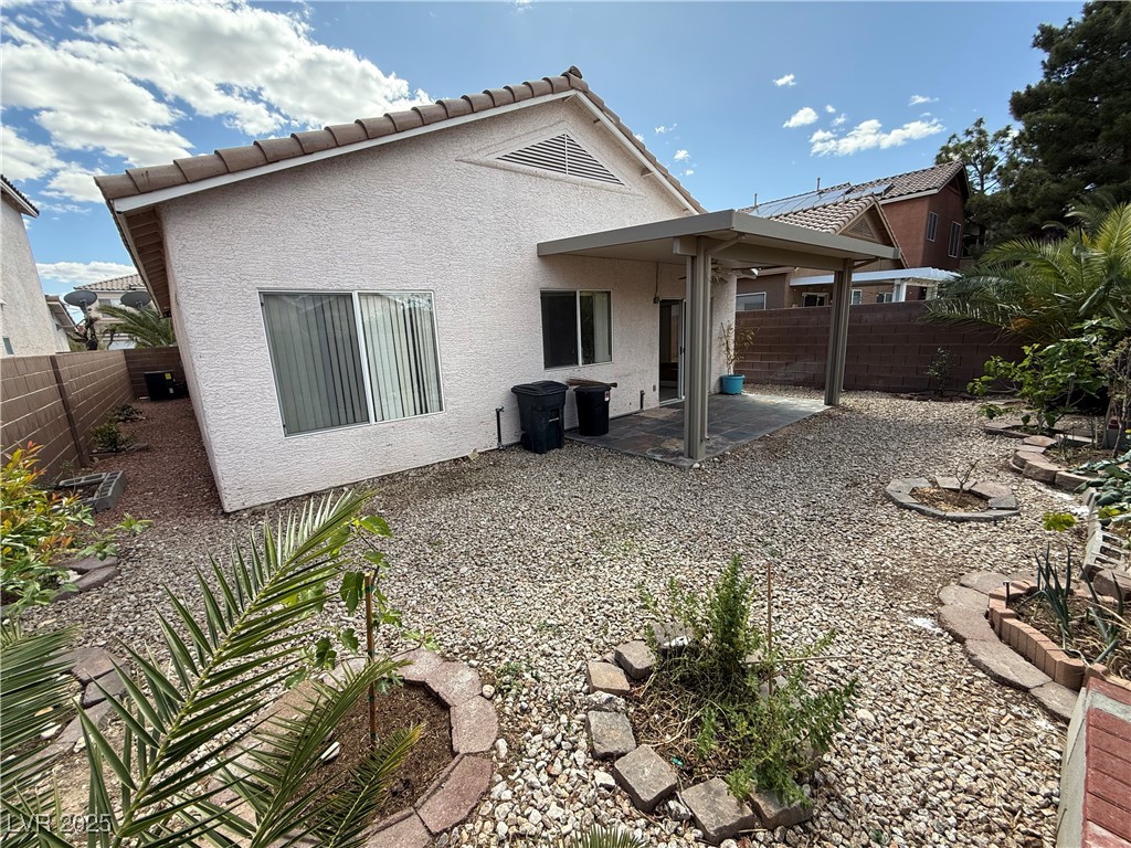 7062 Russell Ranch Avenue Las Vegas, NV 89113 - Photo 15 of 32 Rear view of house featuring stucco siding, a fenced backyard, a tiled roof, and a patio area