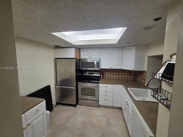 a kitchen with a sink and stainless steel appliances