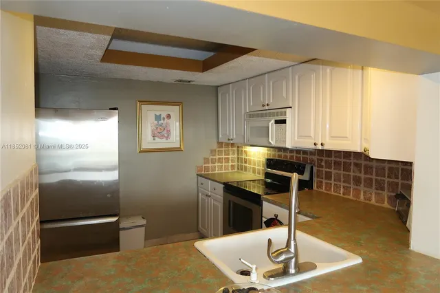 a kitchen with a sink and a refrigerator