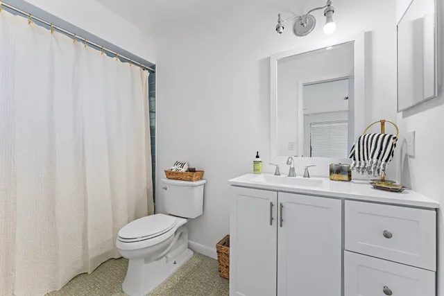 a bathroom with a toilet a sink and mirror