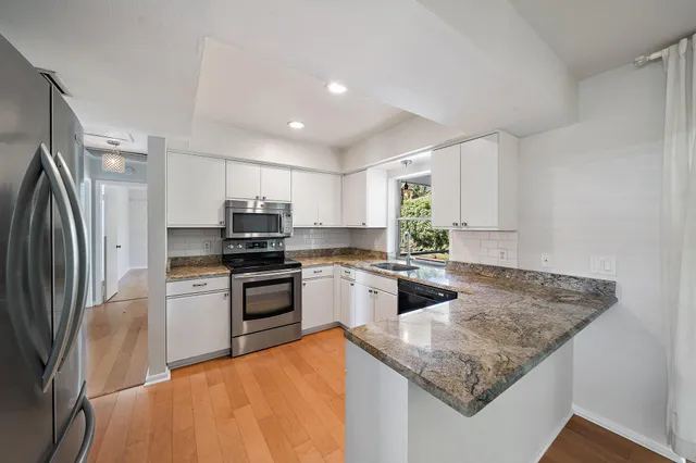 a kitchen with stainless steel appliances granite countertop a sink stove and refrigerator