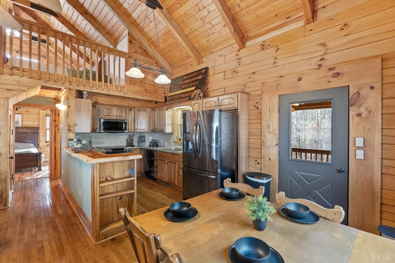 1069 Vineyard Road Spout Spring, VA 24538 - Photo 12 of 60 a kitchen with stainless steel appliances kitchen island granite countertop a refrigerator a stove a sink a dining table and chairs with wooden floor