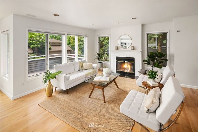 a living room with furniture a fireplace and a floor to ceiling window