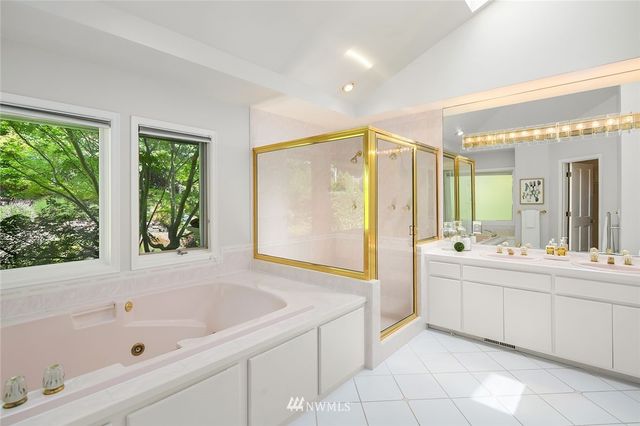 a bathroom with a tub sink and mirror