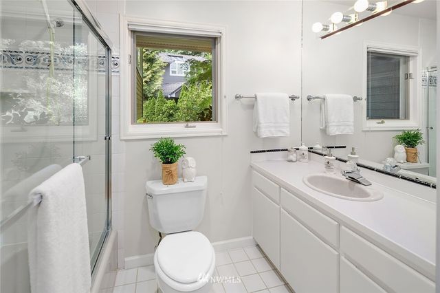 a bathroom with a sink a toilet a mirror and shower