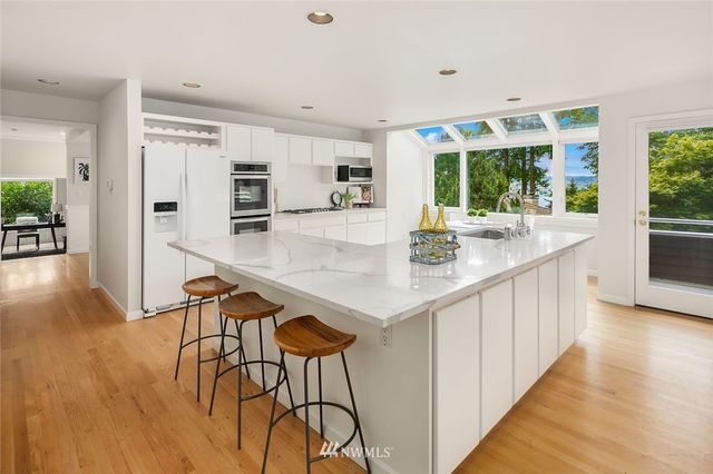 a kitchen with stainless steel appliances granite countertop wooden cabinets and dining table