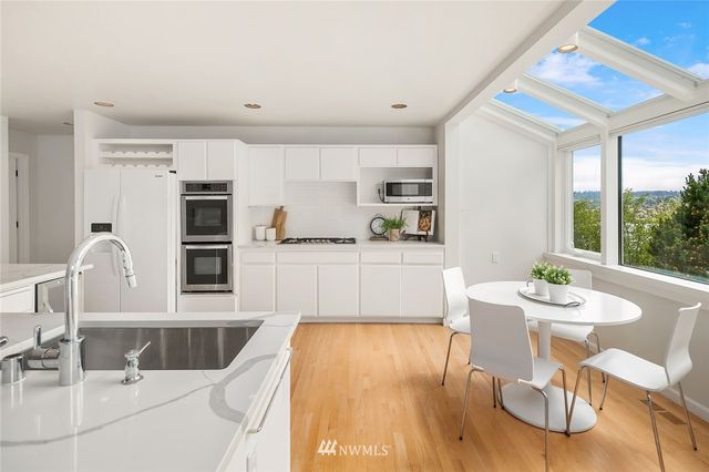 a living room with stainless steel appliances kitchen island granite countertop a table and chairs in it