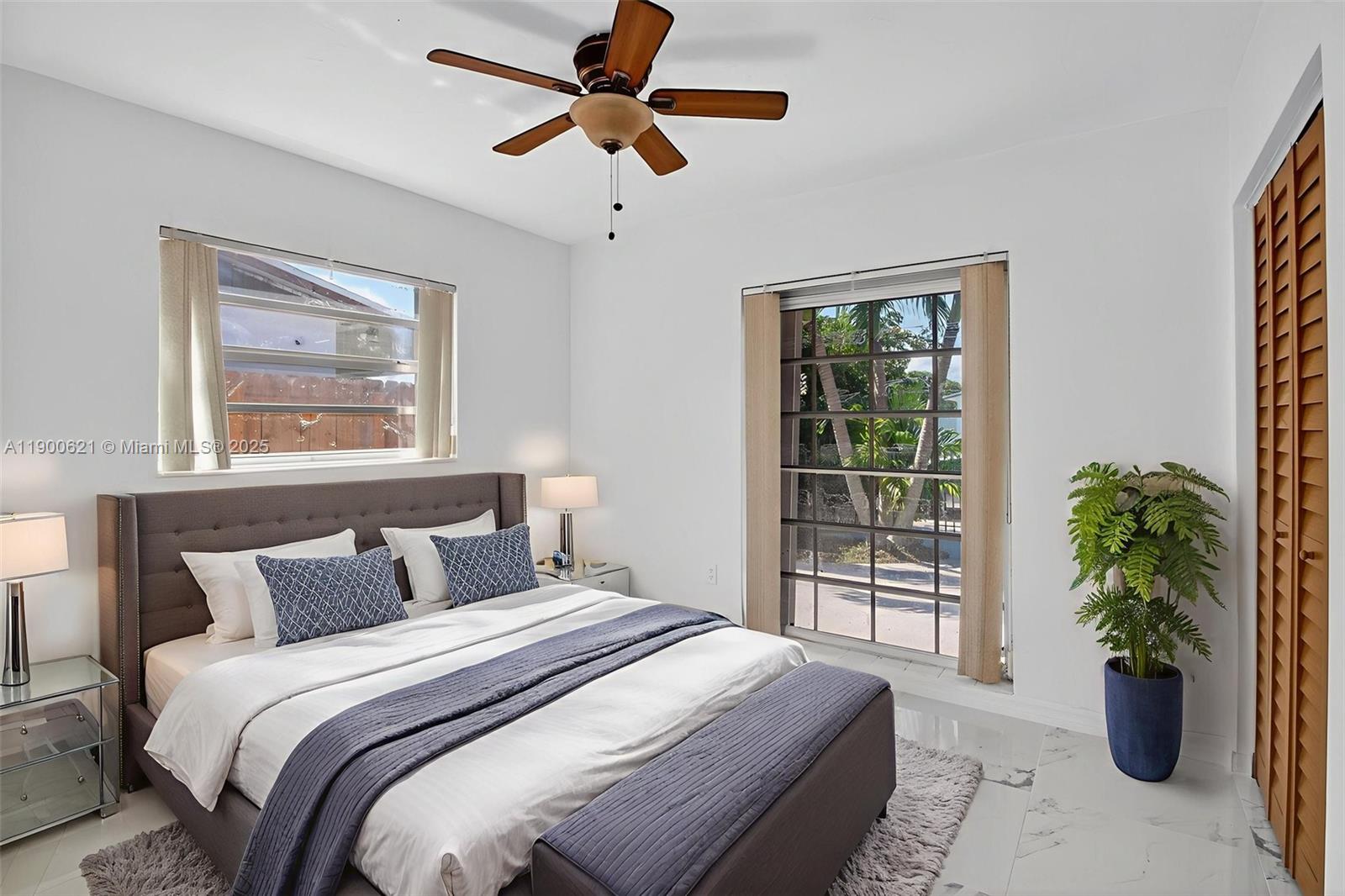 15403 Southwest 107th Court Miami, FL 33157 - Photo 32 of 48 a bedroom with a large bed and a potted plant