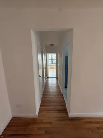 a view of a hallway with wooden floor