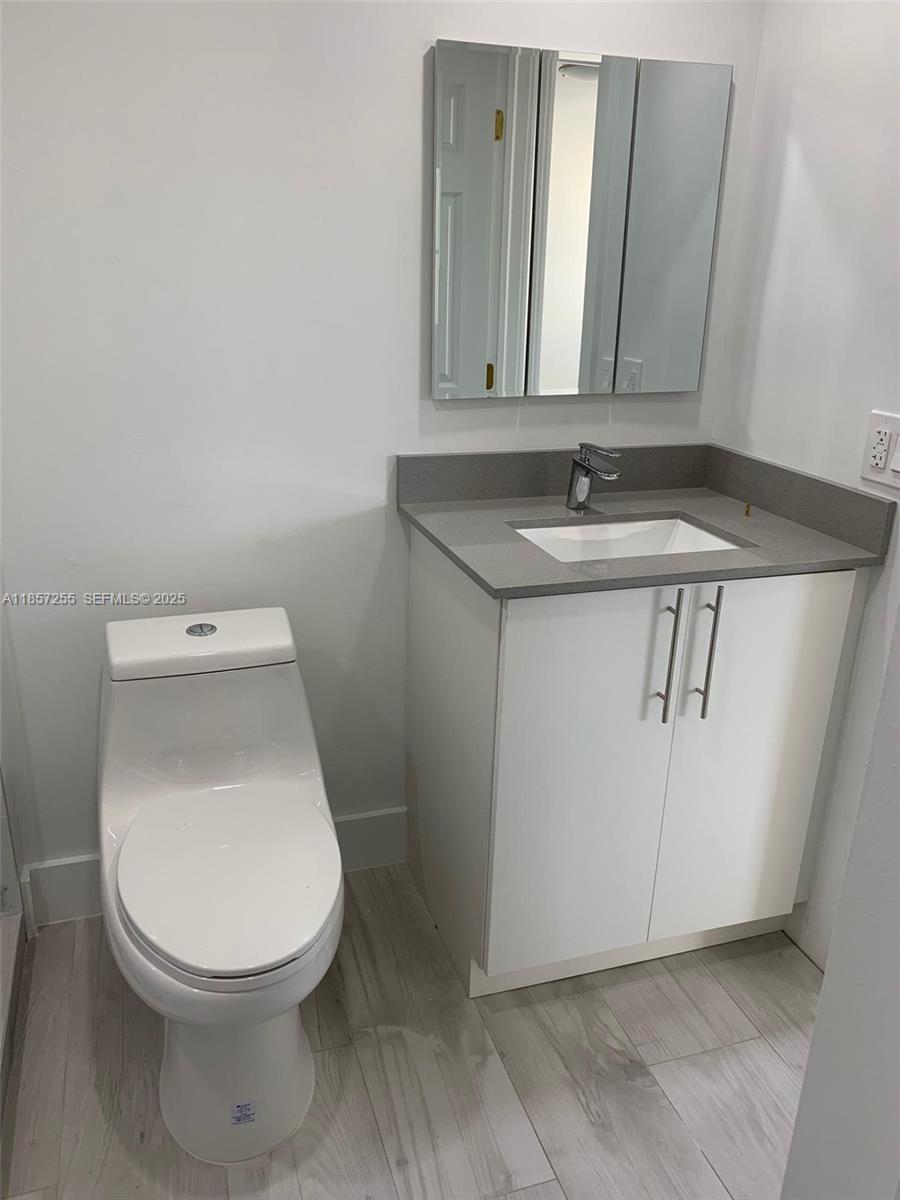 6825 Southwest 45th Lane, Unit 7 Miami, FL 33155 - Photo 14 of 30 a white toilet sitting next to a bathroom sink
