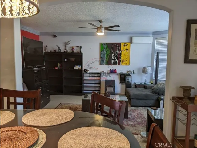 a living room with furniture a table and kitchen view