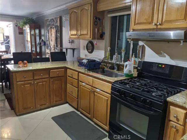 a kitchen with stainless steel appliances granite countertop a stove a sink and a microwave
