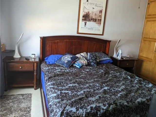 a spacious bedroom with a bed a couch and dresser