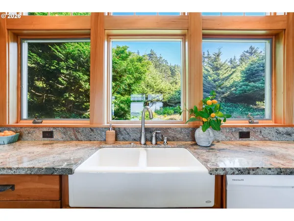 a bathroom with a granite countertop sink and a window