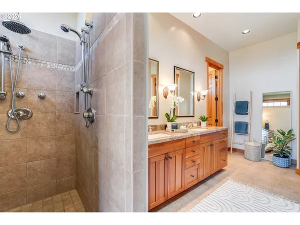 a spacious bathroom with a double vanity sink a large mirror and a shower