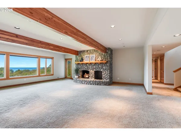 a view of an empty room with a fireplace and a window