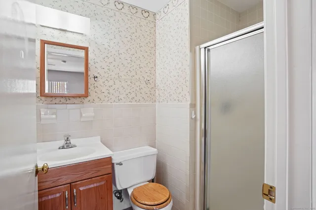a bathroom with a toilet a sink and mirror