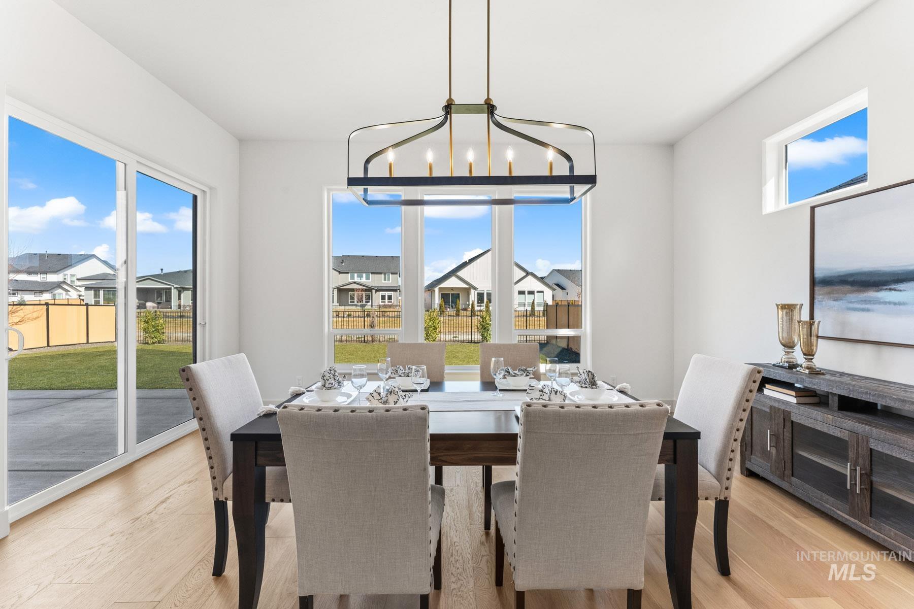 6954 Saddle Bred Way Star, ID 83669 - Photo 15 of 49 Dining area with light wood-style flooring, suspended lighting, and a residential view