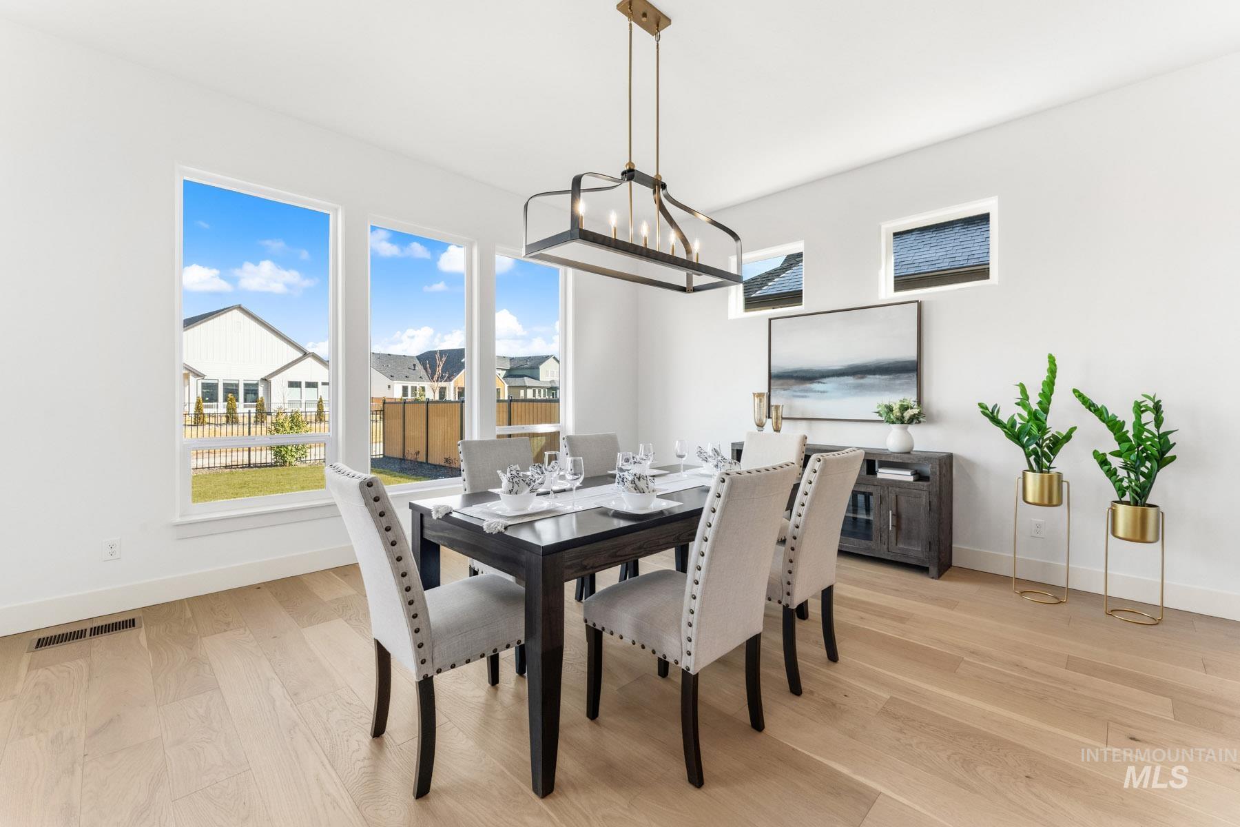 6954 Saddle Bred Way Star, ID 83669 - Photo 16 of 49 Dining space featuring light wood-style floors, plenty of natural light, and suspended lighting