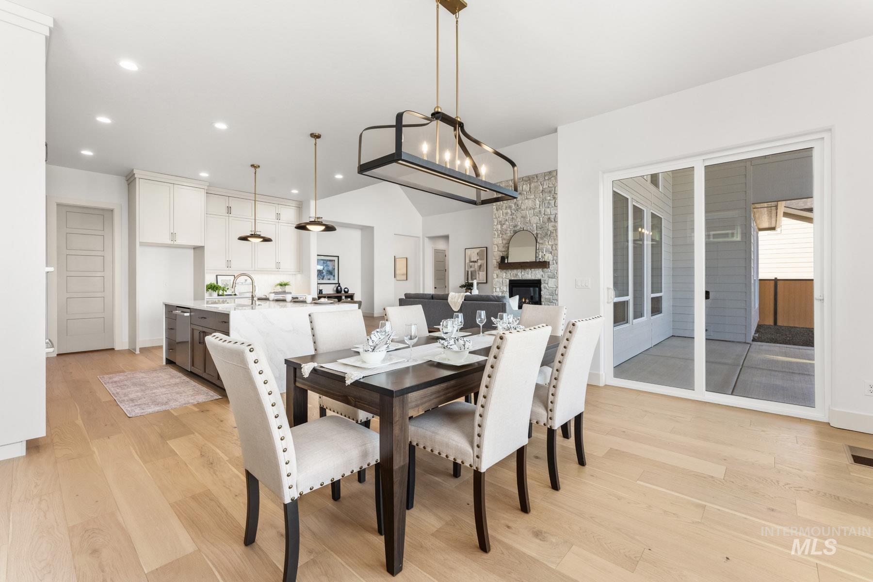 6954 Saddle Bred Way Star, ID 83669 - Photo 17 of 49 Dining room with light wood finished floors, a fireplace, and suspended lighting
