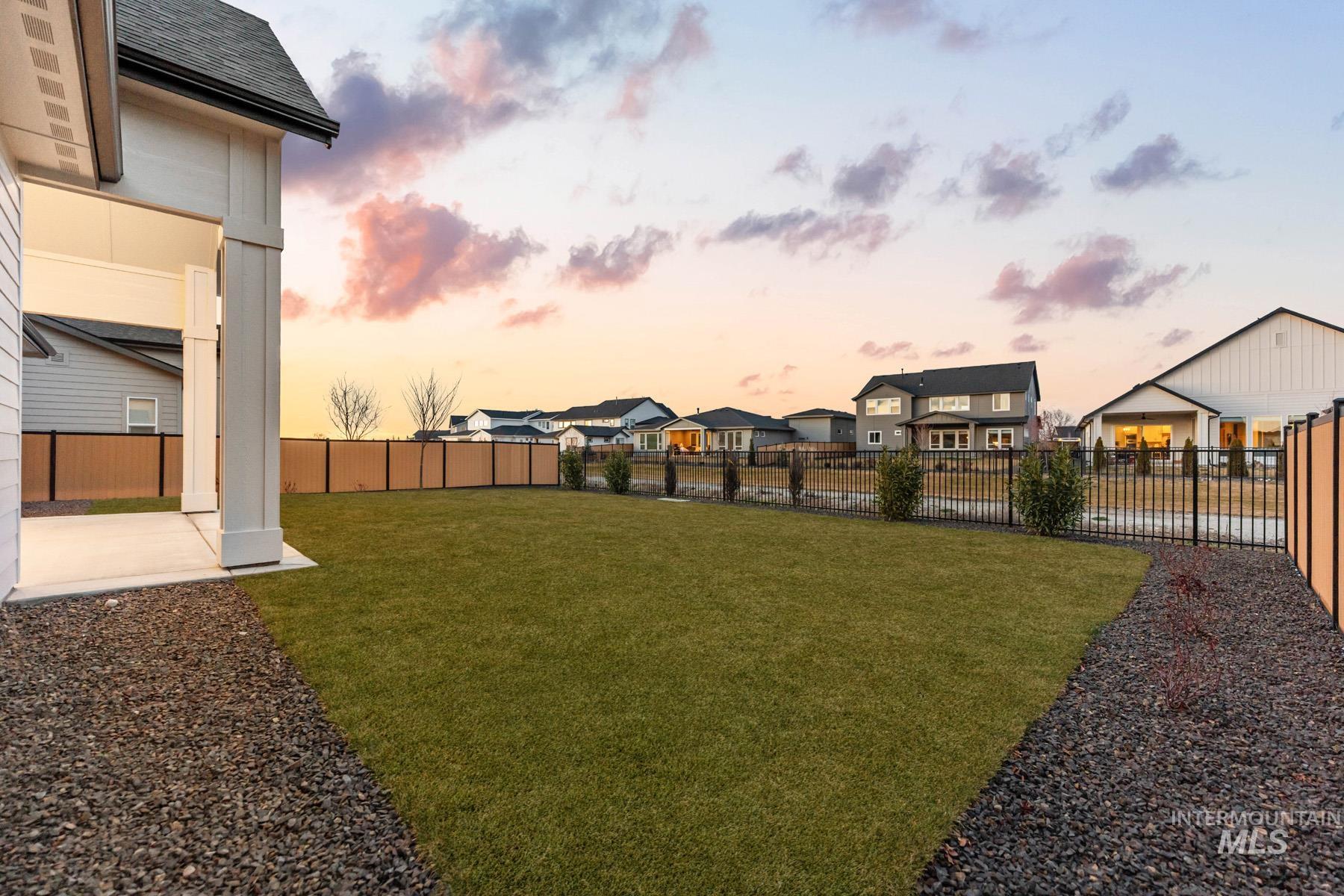 6954 Saddle Bred Way Star, ID 83669 - Photo 3 of 50 Yard at dusk with a fenced backyard, a patio area, and a residential view