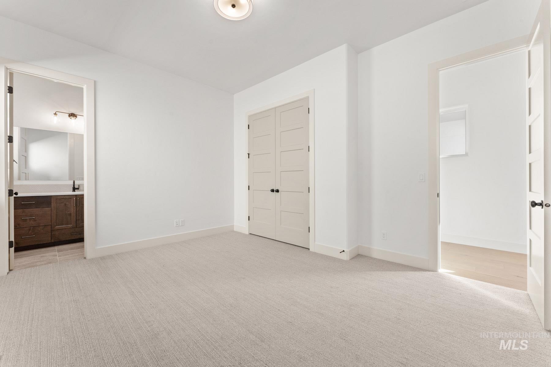 6954 Saddle Bred Way Star, ID 83669 - Photo 30 of 49 Unfurnished bedroom with light carpet, ensuite bath, and a closet